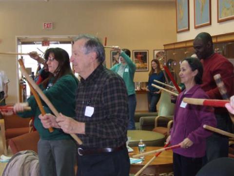 Workshop attendees practice with sticks close up